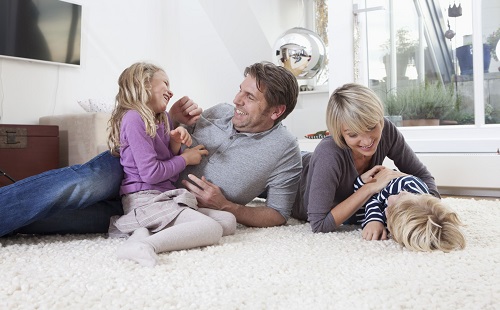 семья лежит играет и балуется на ковре