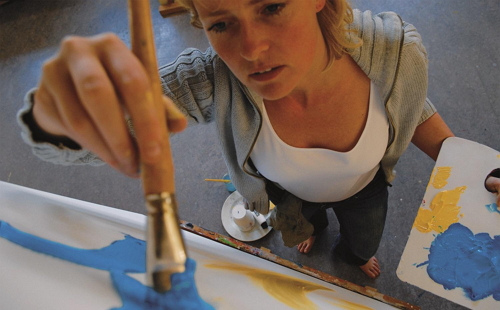 девушка рисует на стене акрилом